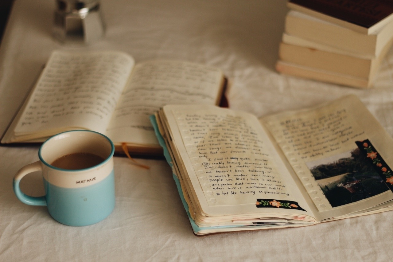Soft daylight notebook resting beside blended tones suggesting reflective journaling.